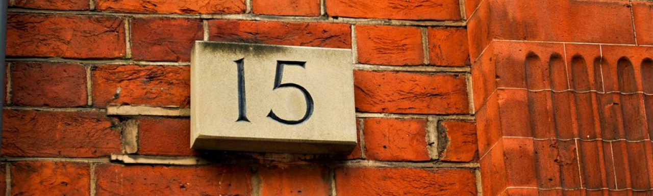 House number on the facade at 15 Palace Court in Bayswater, London W2.