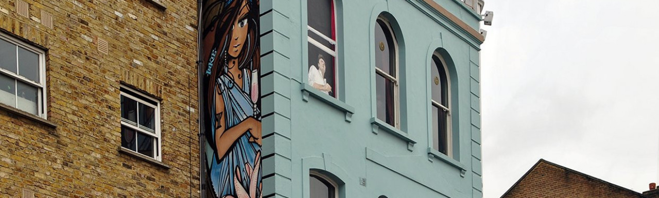 First Floor & girl with a flower on the side of the building in 2013; Street art by Inkie at 186 Portobello Road in Notting Hill, London W11.