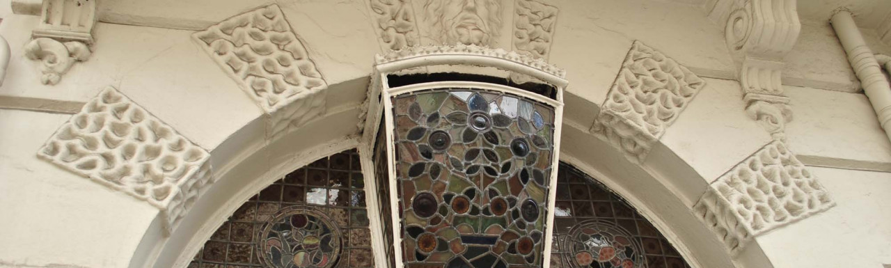 Stained glass fanlight and light above the entrance to 44 Devonshire Street building in Marylebone, London W1.